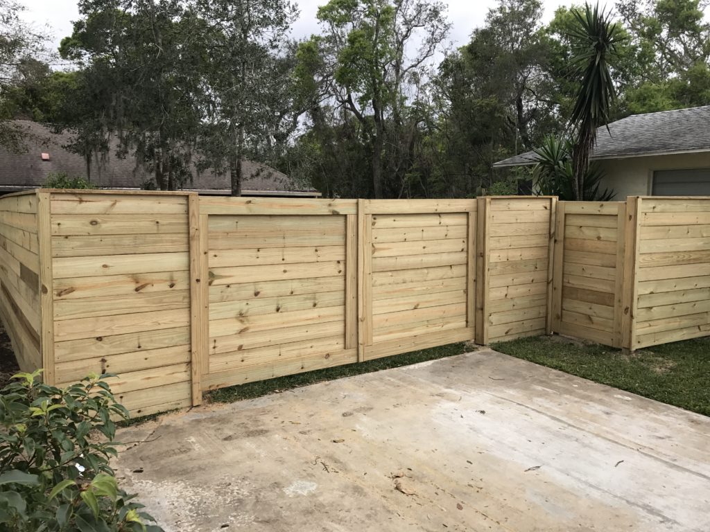 Horizontal wood fence with drive and walk gate.
